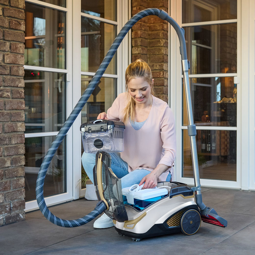 Amfibia Pro 4ALL, женщина извлекает из пылесоса CYCLOON Filter Box и ставит туда Aqua Filter Box